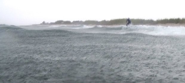 surfer riding a wave in the rain