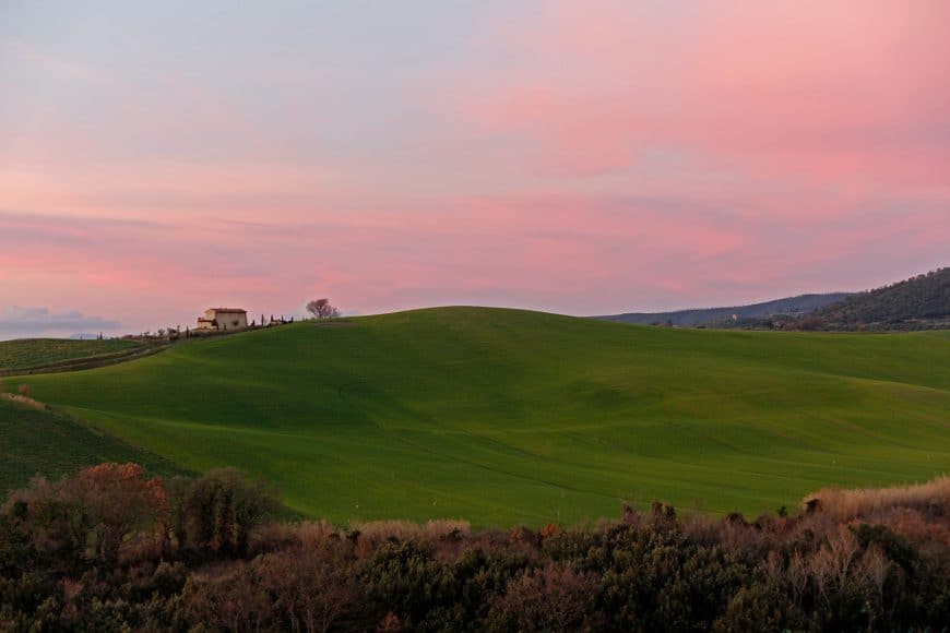 Toscana, green hill, a house on the top and vanilla sky.