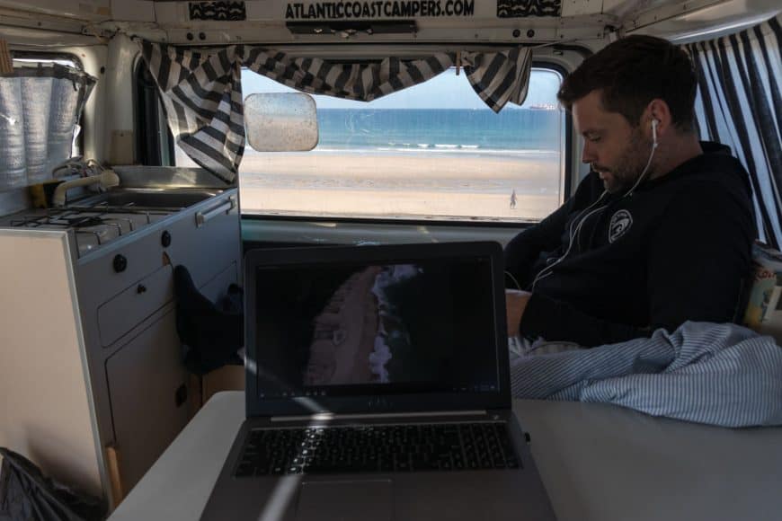 Vanlife shot with the essential laptop "pretending this is my offfice" theme and beach/sea in the background. 
