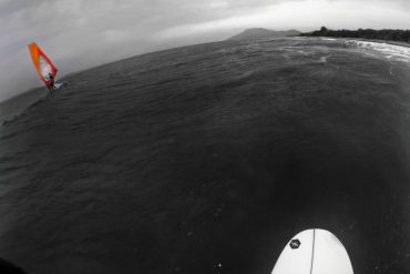 Surfer and windsurfer on sea