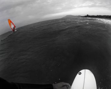 Surfer and windsurfer on sea